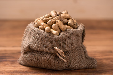 peanuts in sack on wood table