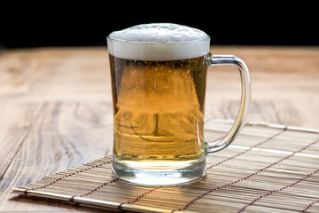 Beer pouring from top in bottle on wood table