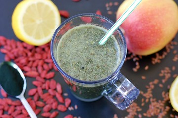 Healthy fresh smoothie drink from red Chinese berry goji, lemon, green spirulina, linseed and apple
