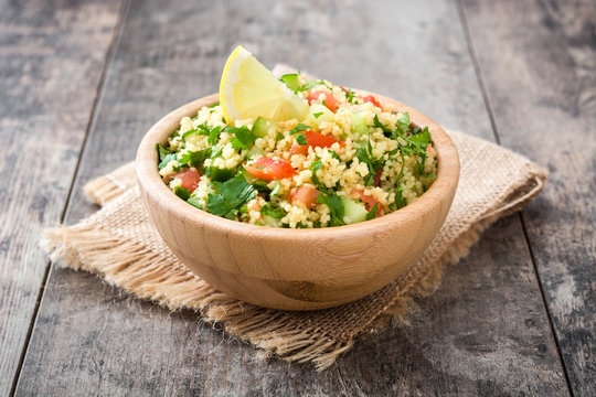 Tabbouleh salad with couscous in bowl on rustic table


