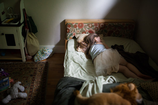 Young girl sleeping on bed in bedroom