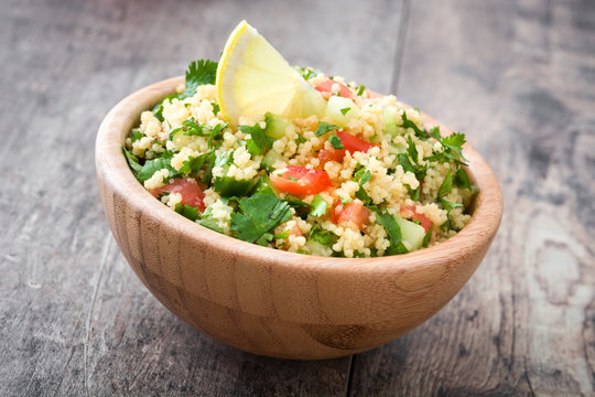 Tabbouleh salad with couscous in bowl on rustic table

