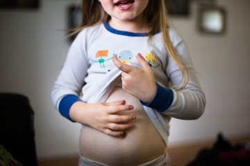 Young girl lifting top, showing belly, mid section