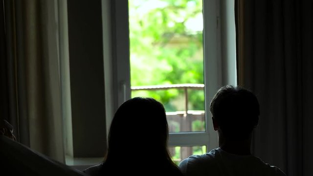 couple sitting in a blanket on window background.
