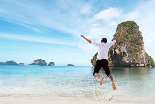Happiness of businessman jumping relax on beautiful sea beach at