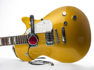Guitarra electrica con auriculares sobre fondo blanco