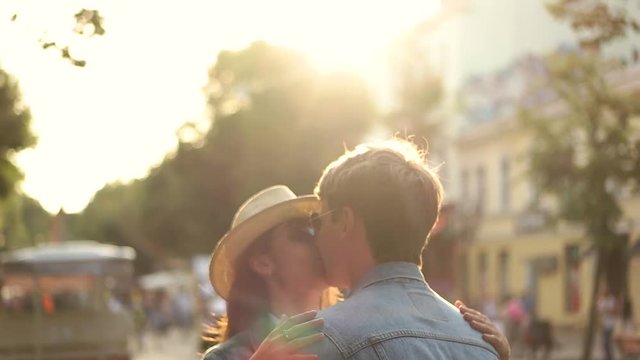couple kissing in the sun in the city.
