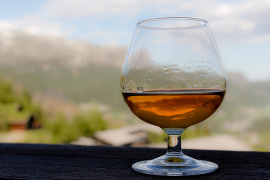 Glas mit Cognac, Whiskey oder Branntwein vor idyllischer Landschaft