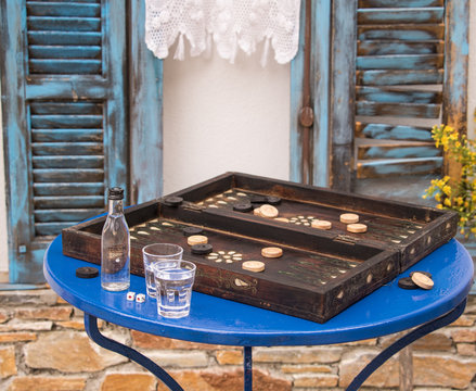 Backgammonspiel mit Aperitif vor alten blauen Fenster