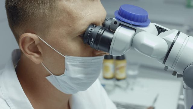 Professional dentist examination patient with microscope
