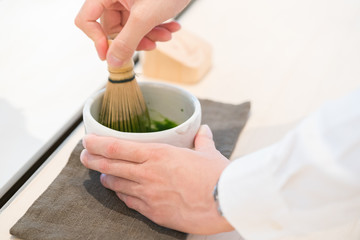 Tea master make matcha tea with tea whisk
