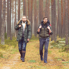 Man with a backpack and beard and his friend in forest