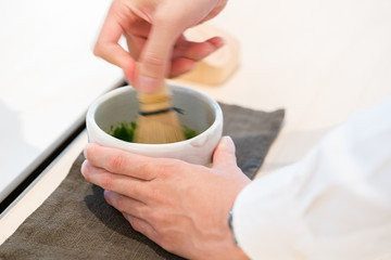 Tea master make matcha tea with tea whisk
