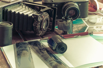 Retro Fotokameras auf einem Tisch / Alte Retro Fotoapparate auf einem Tisch mit Fotografien,...