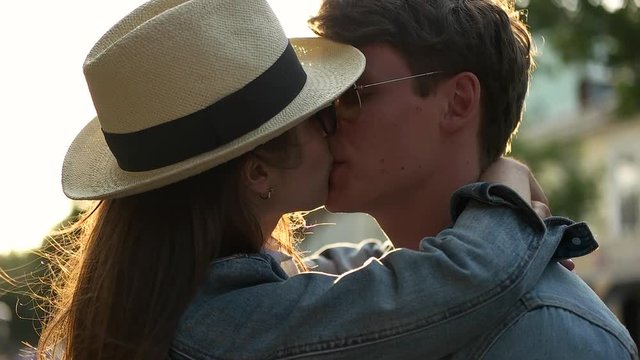 couple in denim shirts kiss.