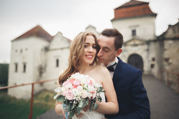 Just married wedding couple posing and bride holding in hands bouquet