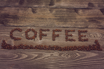 the word coffee made from coffee beans on wooden background