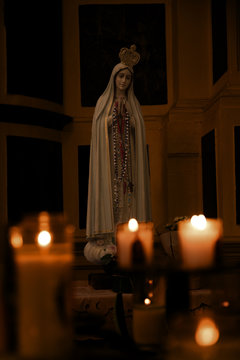 Mariabeeld achter kaarsen
