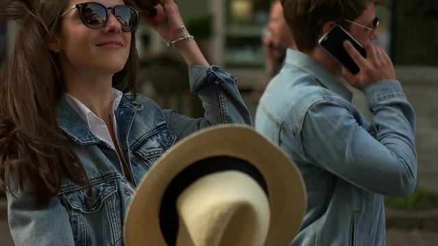 girl takes off hat when walking around the city.