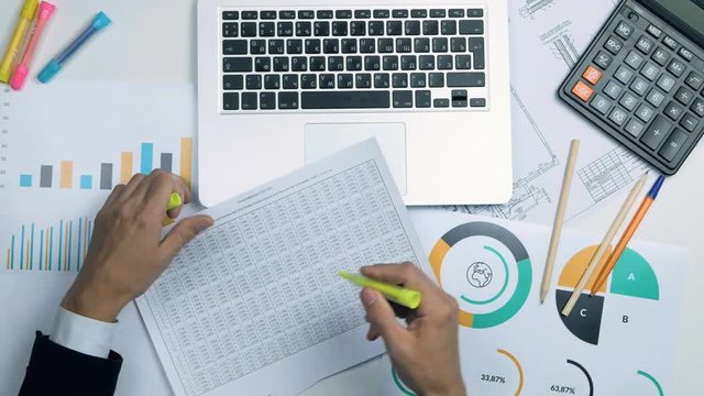 Top view of businessman working at office desk twith laptop, financial infromation. Above view. 4K.