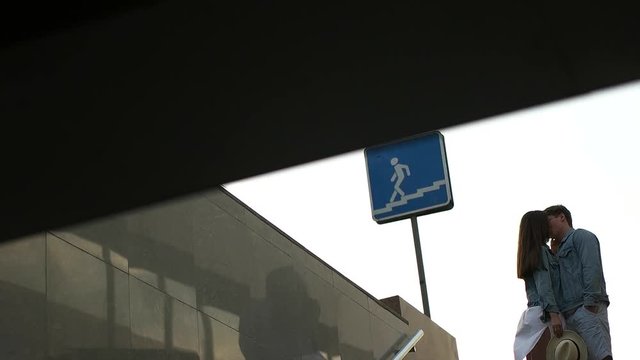 couple kissing near the pedestrian crossing.
