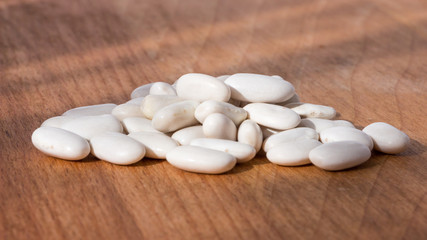 White beans closeup on a wooden background.