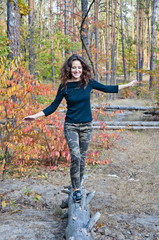 pretty woman in forest on trunk