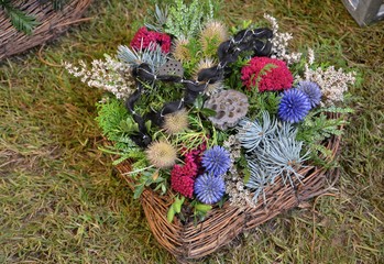 Herz aus Weidengeflecht mit Trauerschleife und bunten Herbstblumen 