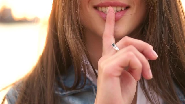 girl puts finger to lip.