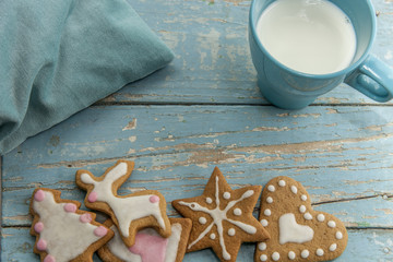 Ginger bread winter cookies with milk and a blue pillow on a blue table