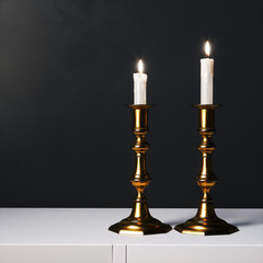 Coper candelabras with candles on the white surface. 3d render