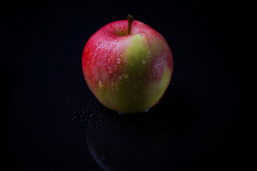 Apple with drops on a black background.