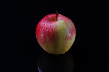 Apple with drops on a black background.
