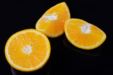 Juicy orange on a black background closeup.