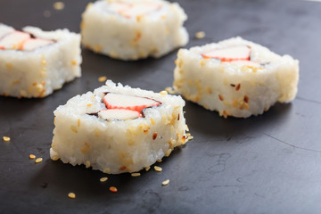Sushi rolls on a black surface