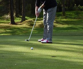 Woman golfing on the putting green