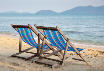 Two beach chairs on idyllic tropical beach.