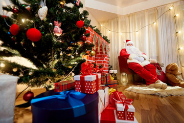 Santa Claus in a chair next to the fireplace at Christmas, New Y