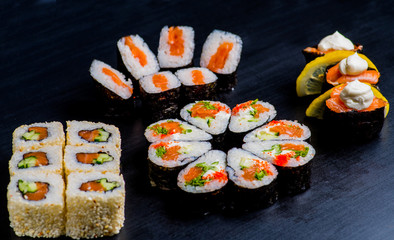 set of Japanese rolls with fish on a black background