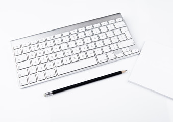 White office computer keyboard with black pencil