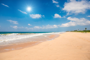 Fototapeta na wymiar Tropical beach with clouds and sun reflection in Sri lanka.