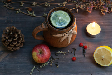 hot herbal tea with lemon and apple on a wooden background
