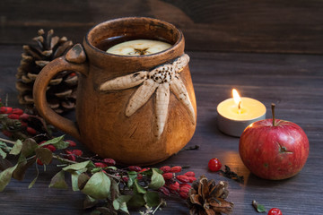 hot herbal tea with lemon and apple on a wooden background