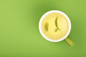 One full big cup of green oolong tea with saucer