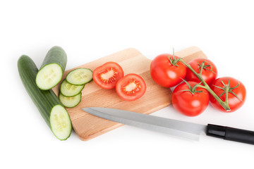 kitchen still life with cucumber, tomato and knife, ingredients for vegetarian food, fresh vegetables in kitchen