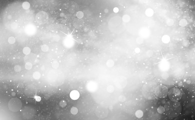 Snowy silver color bokeh with light rays and snowfall background. Silver colored blurry Christmas and New Year greeting card illustration background with sparkle.