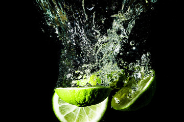 Lemon slices splashing into water.