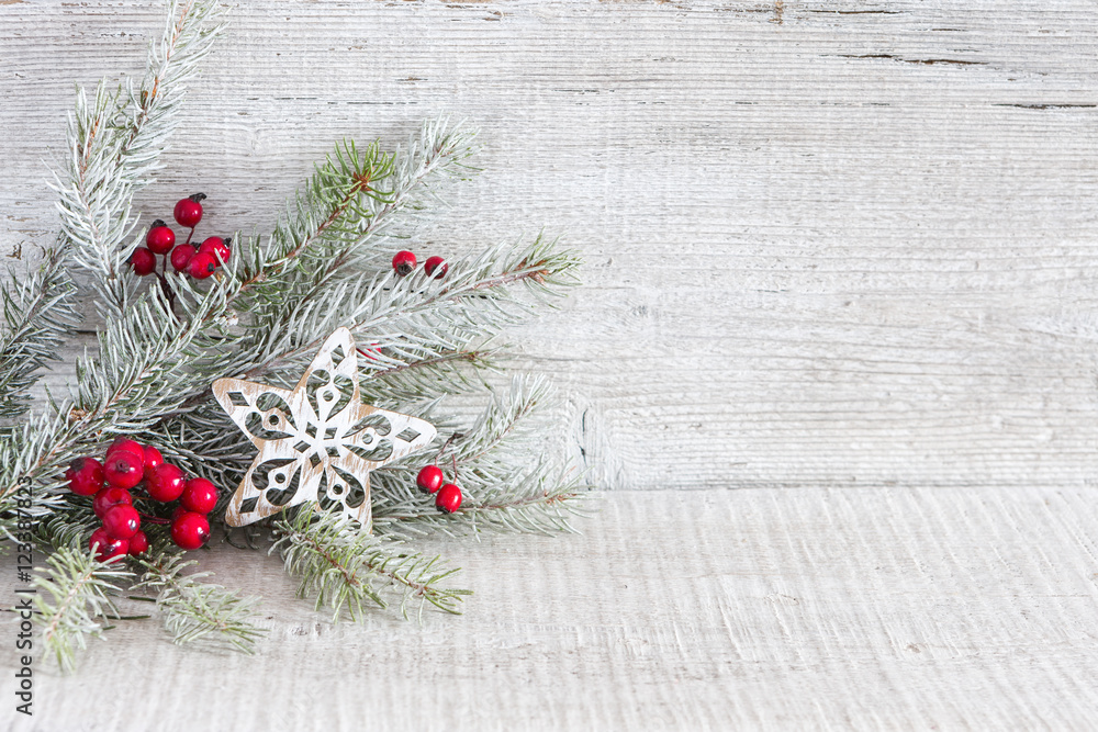 Sticker fir branch with christmas decorations on white rustic wooden background with copy space for text.