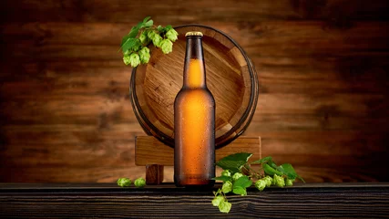 Gordijnen Bottle of cold beer and old barrel on wooden background © nioloxs