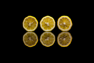 Three cut lemons on black background
